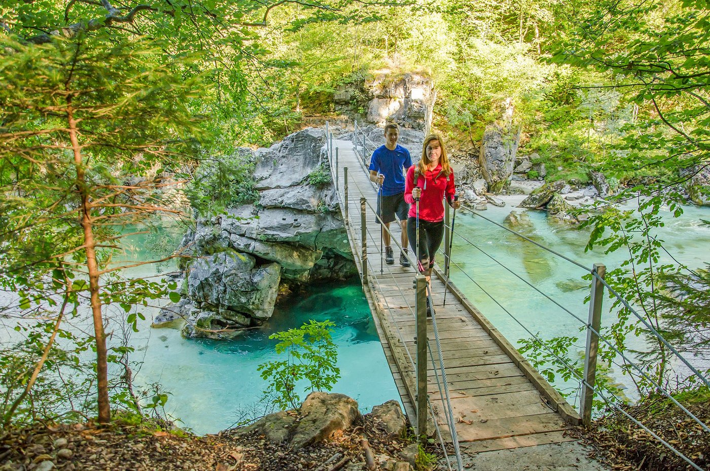 Gli escursionisti attraversano il ponte pedonale sul fiume Isonzo