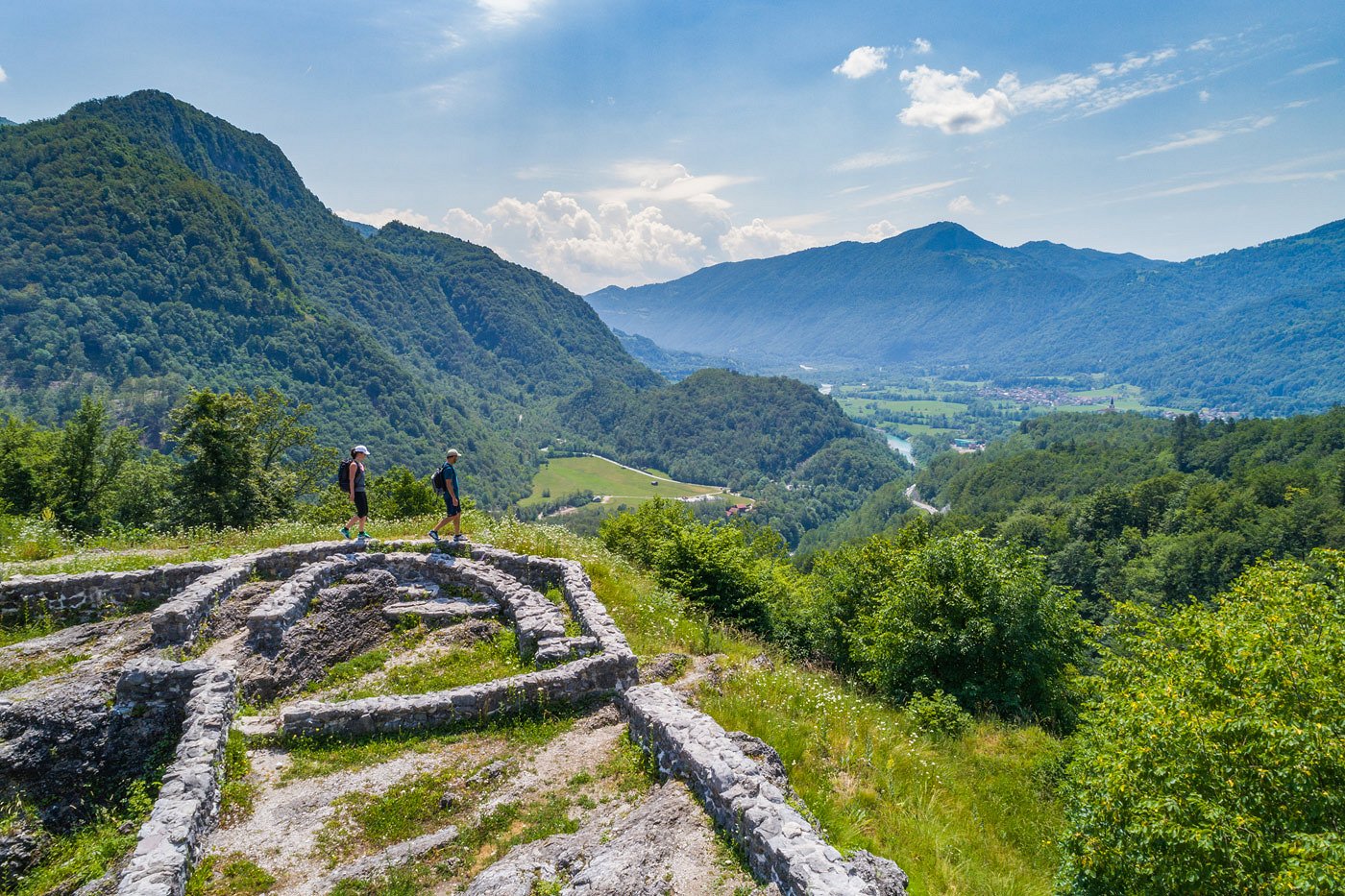 Tonovcov Grad Hill Hikers hike along the remains of the wall and enjoy the view of the valley in which the emerald green Soča River flows.